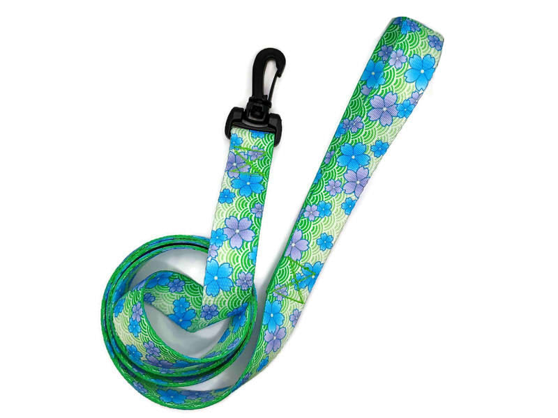 This unique leash features 2 different styles of leash clips for the owners preference! Swivel and Bolt style clips. This image features beautiful blue and purple blossoms on a spring green background. This leash is ideal for dogs with metal allergies or service dogs thru TSA checkpoints.
