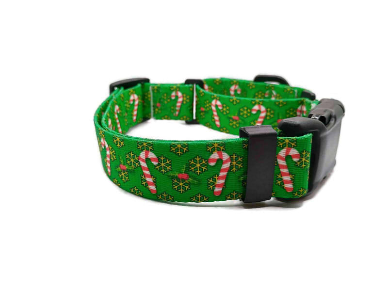 Get festive with this Green Candy Cane TSA martingale collar! Features red and white candy canes on a green background with yellow-golden snowflakes. Unlike our typical metal free TSA martingales, this collar features a quick release buckle in a martingale style for easy on and off! Take the hassle out of adjusting to put it over the head and then fitting to the pups neck. Simply unclip this collar, adjust to size and snap it on! No more adjusting for on and off.