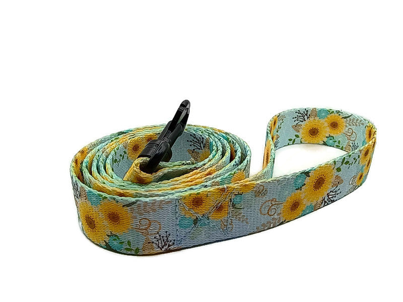 This unique leash features 2 different styles of leash clips for the owners preference! Swivel and Bolt style clips. This image features stunning yellow daisies on a light blue background. This leash is ideal for dogs with metal allergies or service dogs thru TSA checkpoints.