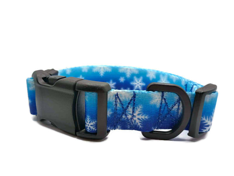 White snowflakes on a cold wintery blue background. This collar features plastic hardware, which is ideal for dogs allergic to metal or service dogs going thru TSA checkpoints.