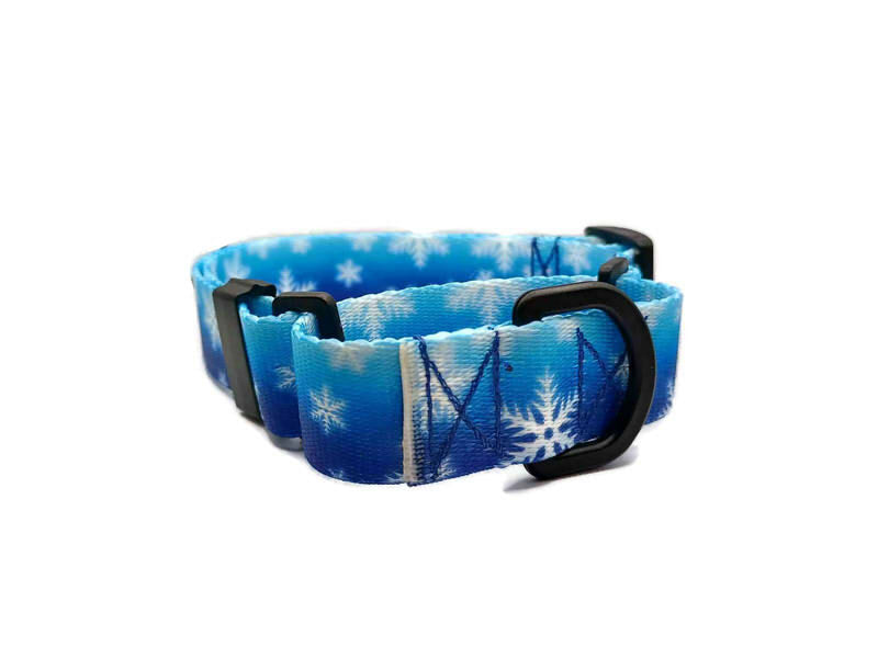 White snowflakes on a cold wintery blue background. This collar features plastic hardware, which is ideal for dogs allergic to metal or service dogs going thru TSA checkpoints.
